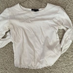 A white long sleeve with ruffles in the bottom